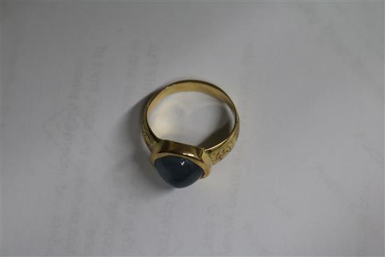 An engraved yellow metal and cabochon star sapphire ring, size O.